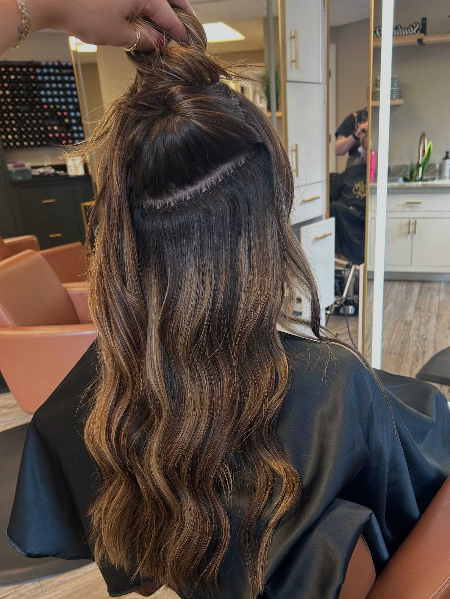 Hair extensions being applied at a salon, showing detailed process and finished look.
